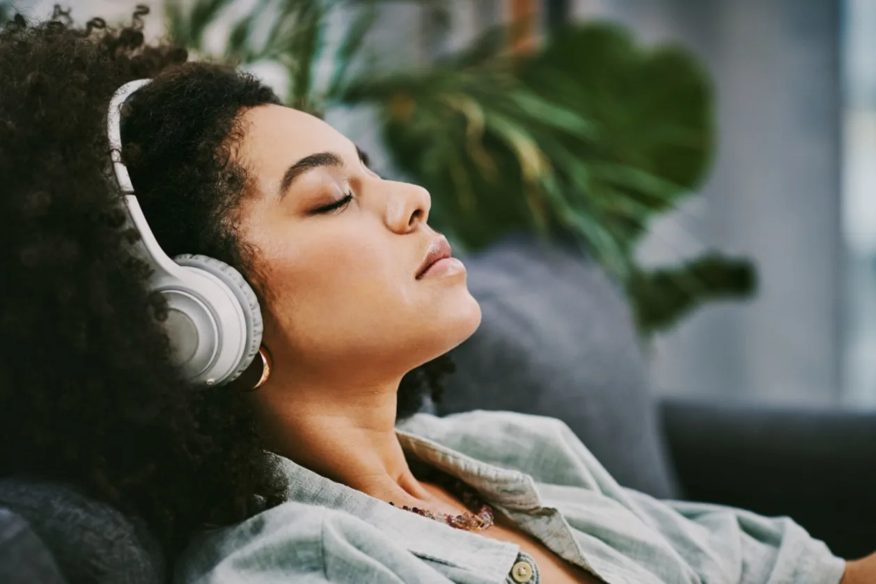 black woman with headphones listening to music for meditation
